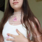 Ein junges Cam-Girl liegt auf ihrem Bett, zeigt ihre Füße und streichelt ihre Muschi.