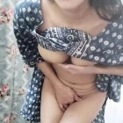 Junge indonesische Frau ist nackt unter ihrem Kleid und streichelt ihre Muschi.